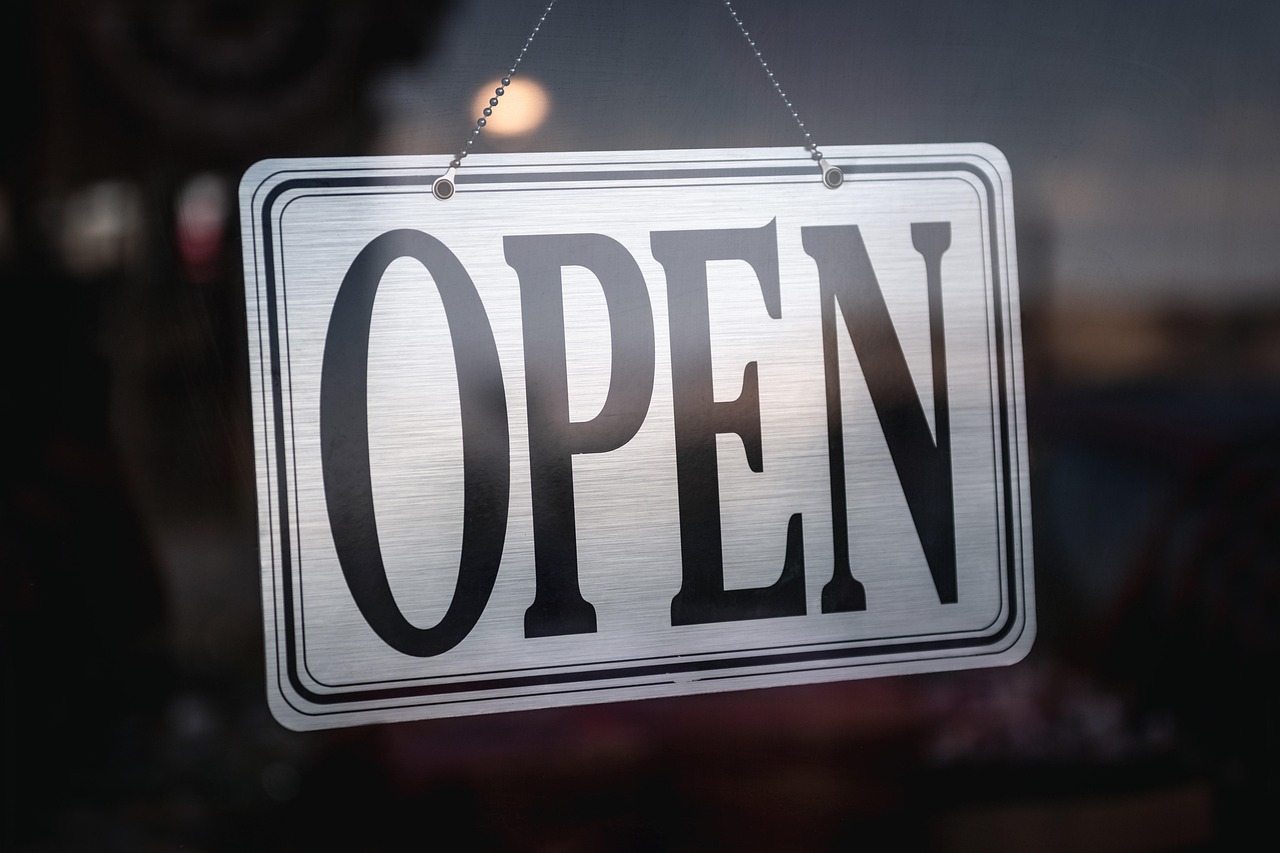 Open sign displayed inside a storefront door